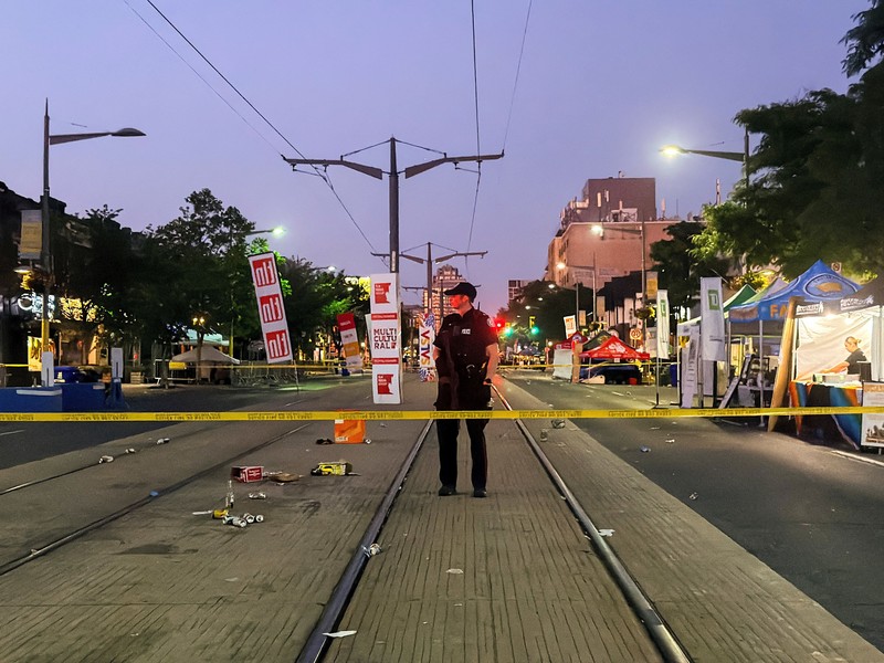 Orang-orang berkumpul saat petugas darurat memberikan pertolongan di lokasi kejadian setelah penembakan mematikan, di sebuah festival jalanan bertema salsa di Toronto, Ontario, Kanada, 11 Juli 2026. (REUTERS/Cole Burston)