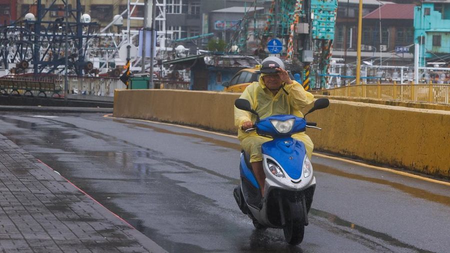 Seorang pria mengendarai skuter di tengah hujan saat Topan Bavi mendekati pantai utara Taiwan di Keelung, Taiwan, 11 Juli 2026.