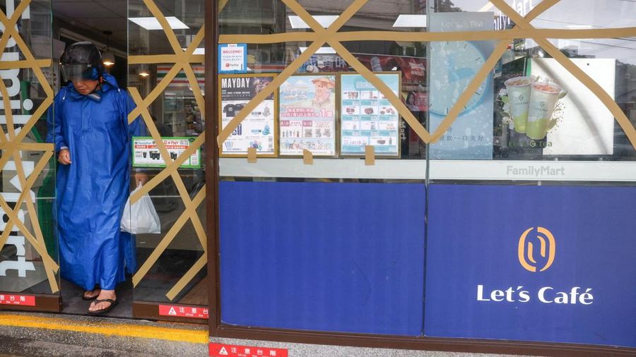 Seorang pria yang mengenakan ponco hujan meninggalkan toko swalayan saat Topan Bavi mendekati pantai utara Taiwan di Keelung, Taiwan, 11 Juli 2026.