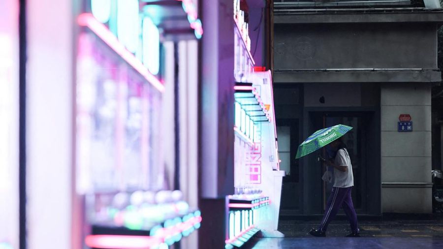 Seseorang berjalan sambil membawa payung saat hujan semakin deras menjelang kedatangan Topan Bavi di Wenzhou, provinsi Zhejiang, Tiongkok, 11 Juli 2026. (REUTERS/Go Nakamura)
