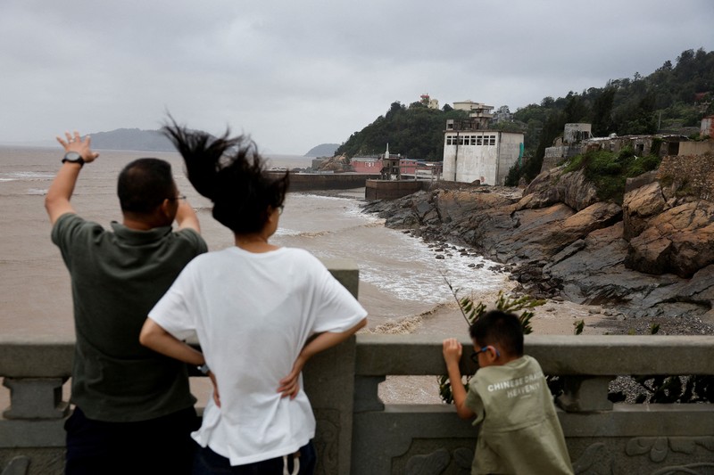 Warga memandang ke arah laut setelah Topan Bavi melanda daerah tersebut di desa pesisir Diaocaocun, Taizhou, provinsi Zhejiang, China, 12 Juli 2026. (REUTERS/Go Nakamura)