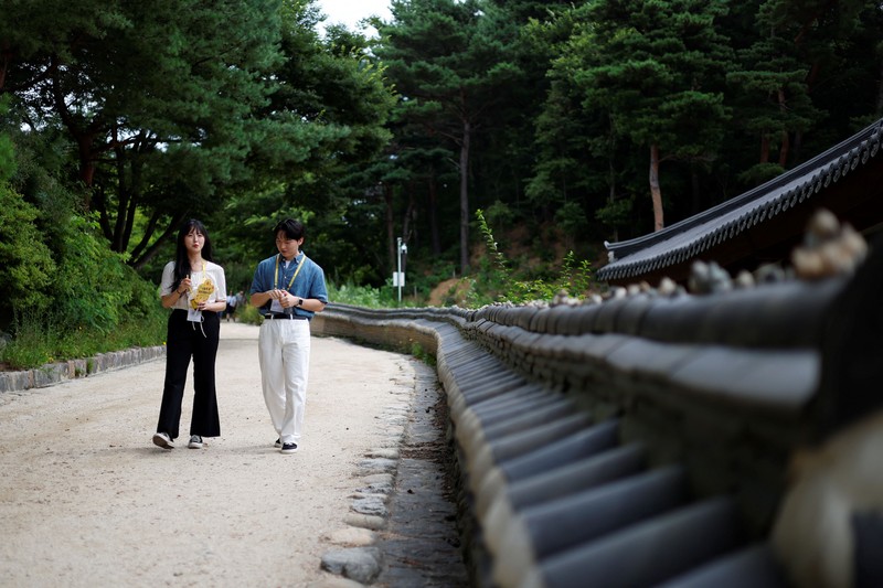 Para peserta berjalan di sekitar halaman kuil Naksansa selama program perjodohan kuil Buddha untuk pria dan wanita lajang di Yangyang, Korea Selatan, 11 Juli 2026. (REUTERS/Kim Soo-hyeon)