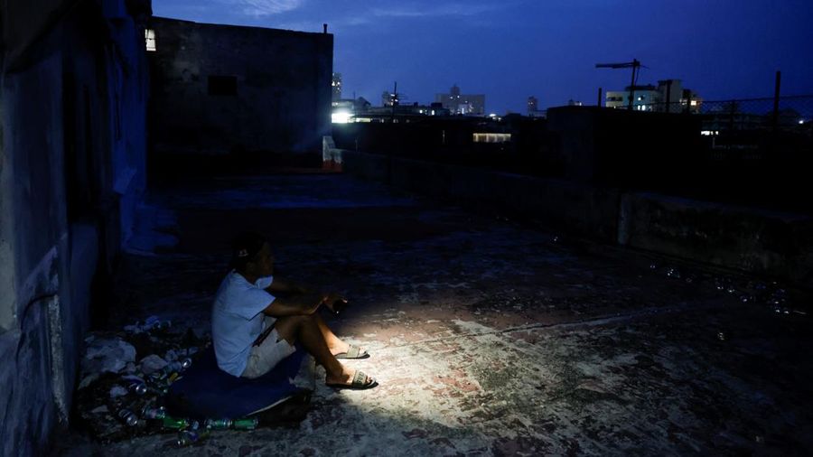 Frank Alfonso, 39 tahun, duduk di atas kasur di atap sebuah gedung untuk menghangatkan diri saat jaringan listrik nasional Kuba runtuh, menandai pemadaman total kedua dalam seminggu di tengah krisis energi parah yang telah menjadikan pemadaman listrik sebagai kenyataan sehari-hari, di Havana, Kuba, 11 Juli 2026.