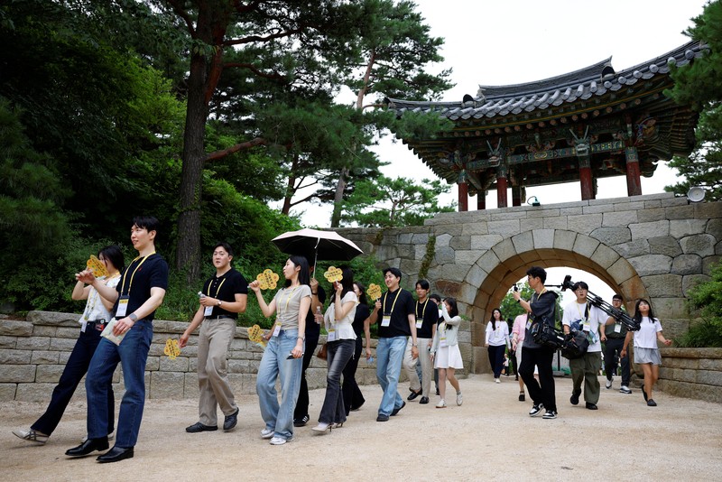 Para peserta berjalan di sekitar halaman kuil Naksansa selama program perjodohan kuil Buddha untuk pria dan wanita lajang di Yangyang, Korea Selatan, 11 Juli 2026. (REUTERS/Kim Soo-hyeon)