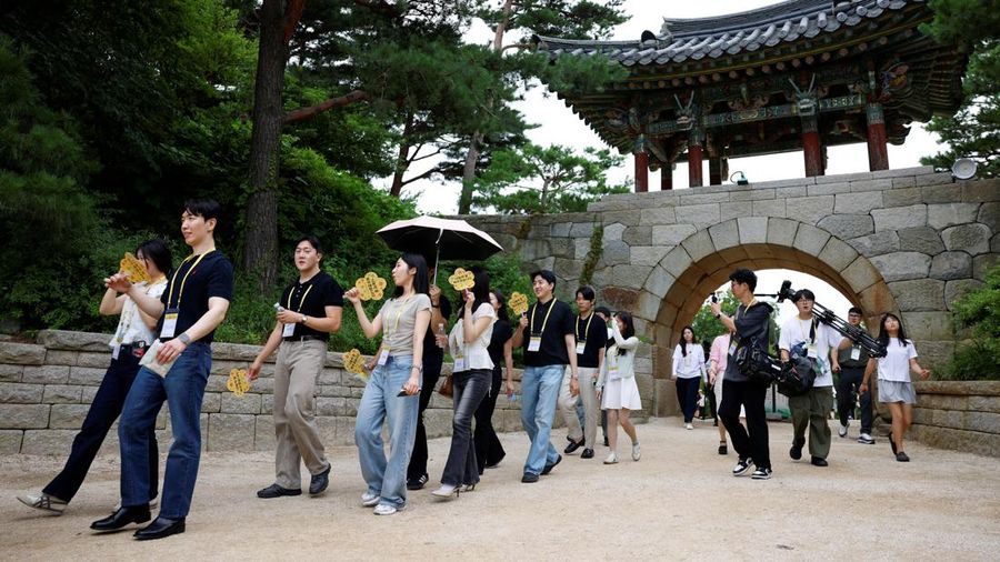 Para peserta berjalan di sekitar halaman kuil Naksansa selama program perjodohan kuil Buddha untuk pria dan wanita lajang di Yangyang, Korea Selatan, 11 Juli 2026. (REUTERS/Kim Soo-hyeon)