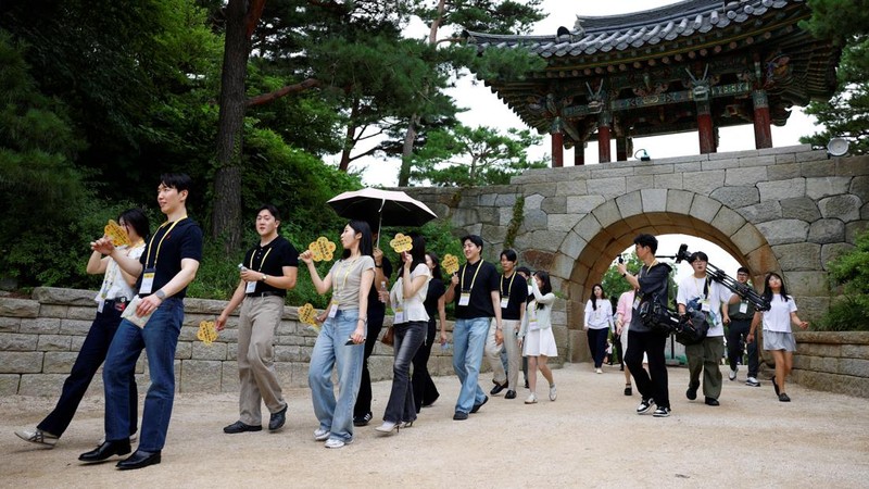 Para peserta berjalan di sekitar halaman kuil Naksansa selama program perjodohan kuil Buddha untuk pria dan wanita lajang di Yangyang, Korea Selatan, 11 Juli 2026. (REUTERS/Kim Soo-hyeon)