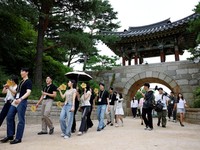 Para peserta berjalan di sekitar halaman kuil Naksansa selama program perjodohan kuil Buddha untuk pria dan wanita lajang di Yangyang, Korea Selatan, 11 Juli 2026. (REUTERS/Kim Soo-hyeon)