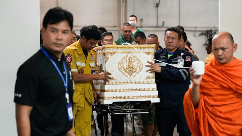 Para petugas layanan darurat memindahkan peti mati berisi jenazah korban di kamar mayat Rumah Sakit Polisi, menyusul kebakaran mematikan di sebuah pub di Bangkok, Thailand, 13 Juli 2026.