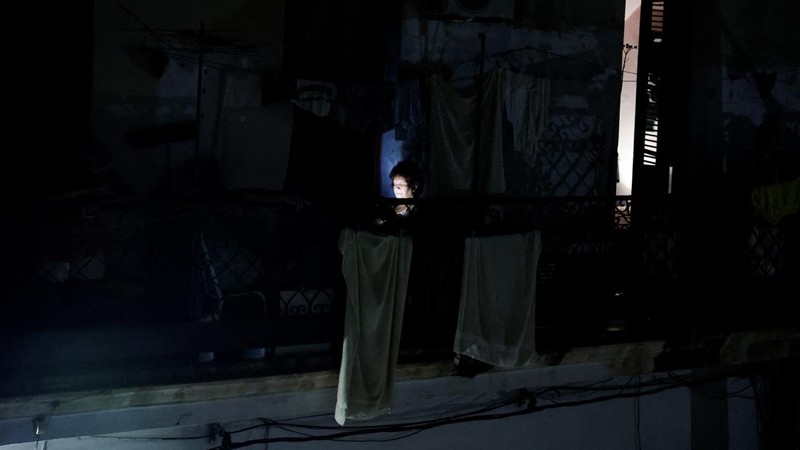 Para tetangga berkumpul di balkon untuk menghangatkan diri saat jaringan listrik nasional Kuba runtuh, menandai pemadaman total kedua dalam seminggu di tengah krisis energi parah yang telah menjadikan pemadaman listrik sebagai kenyataan sehari-hari, di Havana, Kuba, 11 Juli 2026.