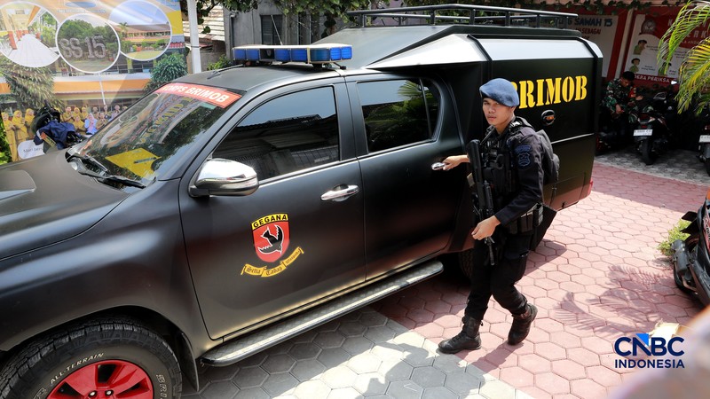 Petugas kepolisian bersenjata berjaga di dalam SDN Srengseng Sawah 15, Jakarta, Senin, (13/7/2026).  Sebuah teror ancaman bom terjadi di hari pertama masa pengenalan lingkungan sekolah (MPLS). (CNBC Indonesia/Muhammad Sabki)