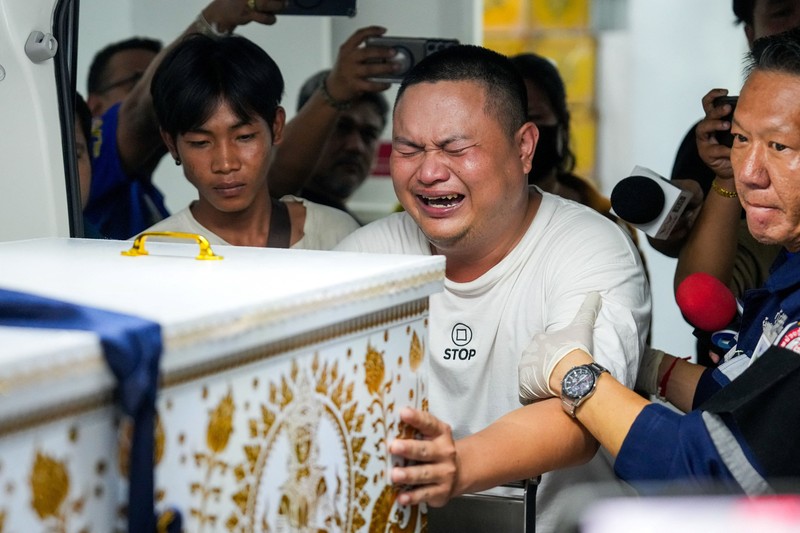 Seorang anggota keluarga bereaksi saat menerima jenazah korban di kamar mayat Rumah Sakit Polisi, setelah kebakaran mematikan di sebuah pub di Bangkok, Thailand, 13 Juli 2026. (REUTERS/Arnun Chonmahatrakool)