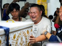 Seorang anggota keluarga bereaksi saat menerima jenazah korban di kamar mayat Rumah Sakit Polisi, setelah kebakaran mematikan di sebuah pub di Bangkok, Thailand, 13 Juli 2026. (REUTERS/Arnun Chonmahatrakool)