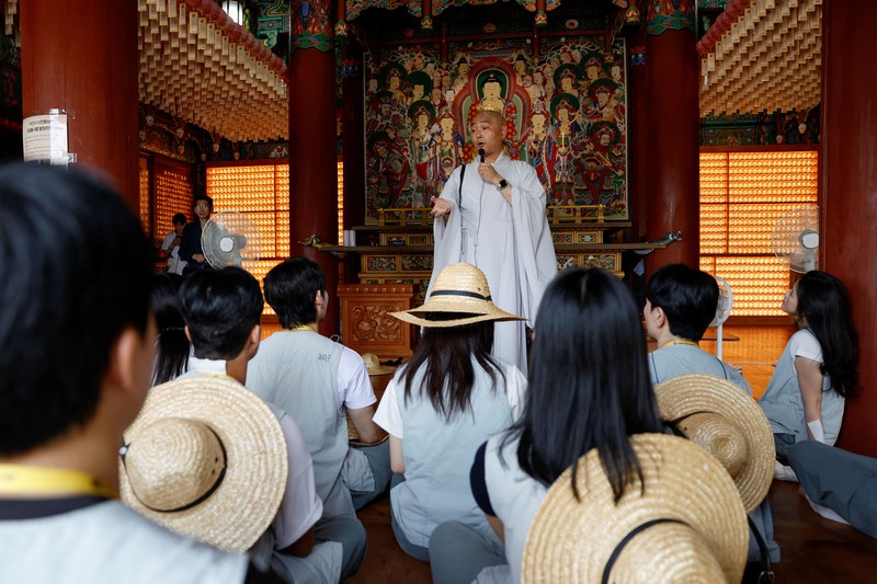 Para peserta berjalan di sekitar halaman kuil Naksansa selama program perjodohan kuil Buddha untuk pria dan wanita lajang di Yangyang, Korea Selatan, 11 Juli 2026. (REUTERS/Kim Soo-hyeon)