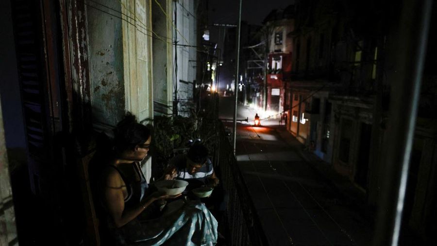 Warga sebuah gedung apartemen, yang dikenal di Kuba sebagai "solar," makan malam di balkon saat jaringan listrik nasional Kuba runtuh, menandai pemadaman total kedua dalam seminggu di tengah krisis energi parah yang telah menjadikan pemadaman listrik