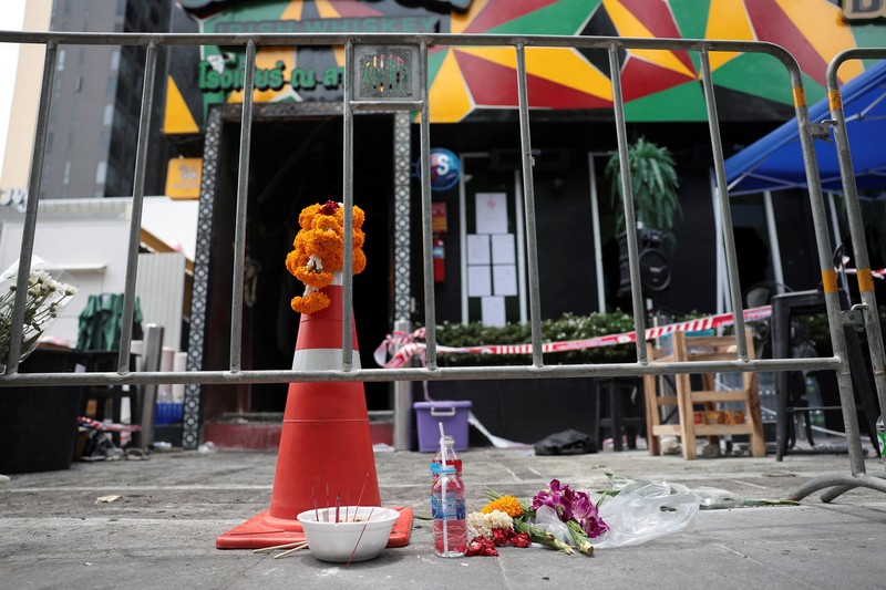Bunga dan persembahan diletakkan di luar bar Rong Beer Na Lat Phrao, lokasi kebakaran mematikan, untuk memberi penghormatan kepada para korban yang kehilangan nyawa dalam kebakaran bar tersebut, sehari setelah kejadian, di Bangkok, Thailand, 14 Juli 2026. (REUTERS/Chalinee Thirasupa)