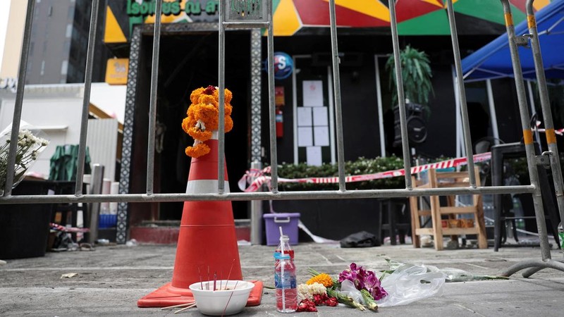 Bunga dan persembahan diletakkan di luar bar Rong Beer Na Lat Phrao, lokasi kebakaran mematikan, untuk memberi penghormatan kepada para korban yang kehilangan nyawa dalam kebakaran bar tersebut, sehari setelah kejadian, di Bangkok, Thailand, 14 Juli 2026.
