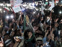 Pendukung Houthi mengangkat senjata saat mereka berdemonstrasi menentang serangan udara di Bandara Internasional Sanaa, di Sanaa, Yaman, 13 Juli 2026. (REUTERS/Khaled Abdullah)