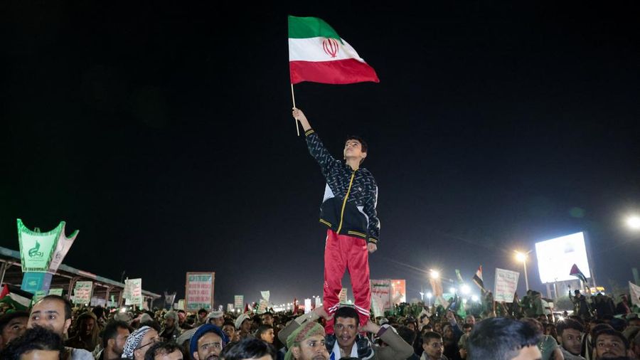 Seorang anak laki-laki melambaikan bendera Iran saat bergabung dengan pendukung Houthi dalam demonstrasi menentang serangan udara di Bandara Internasional Sanaa, di Sanaa, Yaman, 13 Juli 2026. (REUTERS/Khaled Abdullah)