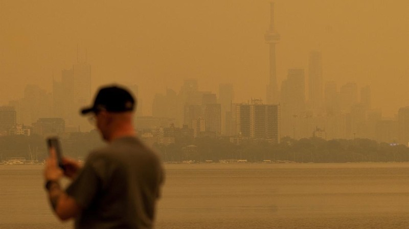 Asap kebakaran hutan dari Ontario barat laut, dikombinasikan dengan gelombang panas yang hebat, memenuhi langit saat seseorang mengambil foto, memicu peringatan kesehatan dan seruan kepada warga untuk membatasi aktivitas di luar ruangan di Toronto, Ontario, Kanada, 15 Juli 2026.