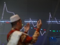 Ilustrasi berdoa dengan latar belakang Indeks Harga Saham Gabungan (IHSG) di Gedung Bursa Efek Indonesia (BEI), Jakarta. (CNBC Indonesia/Faisal Rahman)