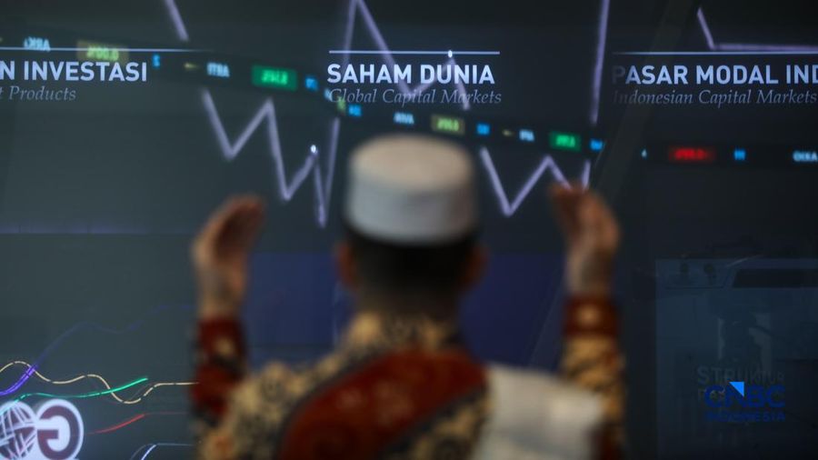 Ilustrasi berdoa dengan latar belakang Indeks Harga Saham Gabungan (IHSG) di Gedung Bursa Efek Indonesia (BEI), Jakarta. (CNBC Indonesia/Faisal Rahman)