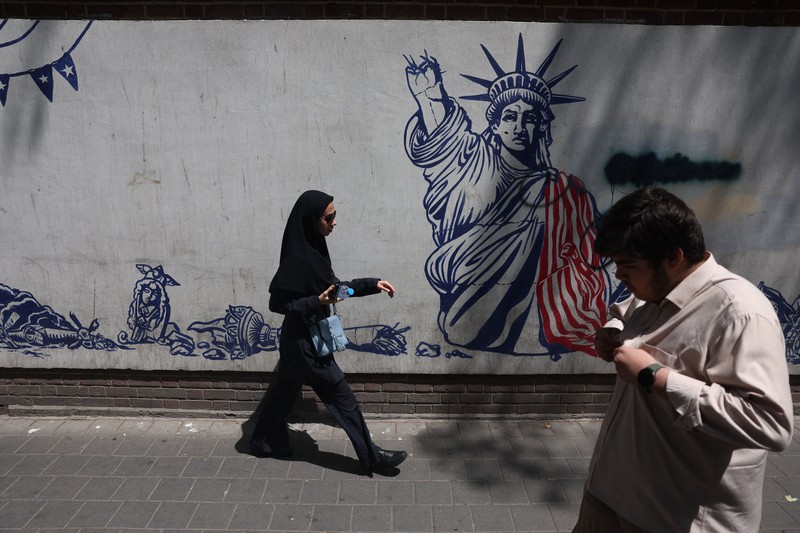 Papan reklame raksasa yang menampilkan ilustrasi Presiden AS Donald Trump berada di dalam peti mati yang terpampang di pusat kota Teheran, Kamis (16/7/2026). (via REUTERS/Majid Asgaripour)