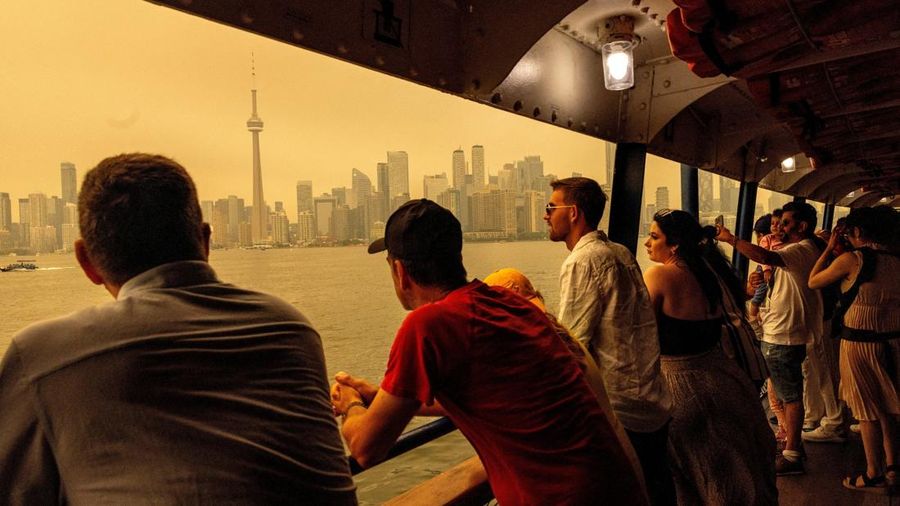 Orang-orang menaiki feri menuju Pulau Toronto, sementara asap kebakaran hutan dari Ontario barat laut, dikombinasikan dengan gelombang panas yang hebat, memenuhi langit, memicu peringatan kesehatan dan seruan kepada warga untuk membatasi aktivitas di luar ruangan di Toronto, Ontario, Kanada, 15 Juli 2026.