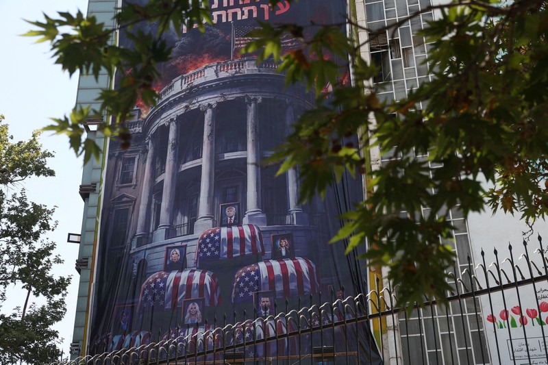 Papan reklame raksasa yang menampilkan ilustrasi Presiden AS Donald Trump berada di dalam peti mati yang terpampang di pusat kota Teheran, Kamis (16/7/2026). (via REUTERS/Majid Asgaripour)