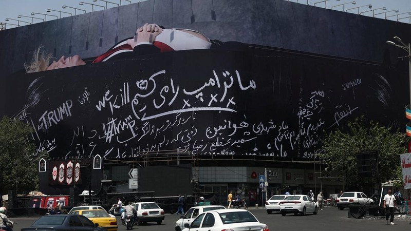 Papan reklame raksasa yang menampilkan ilustrasi Presiden AS Donald Trump berada di dalam peti mati yang terpampang di pusat kota Teheran, Kamis (16/7/2026). (via REUTERS/Majid Asgaripour)