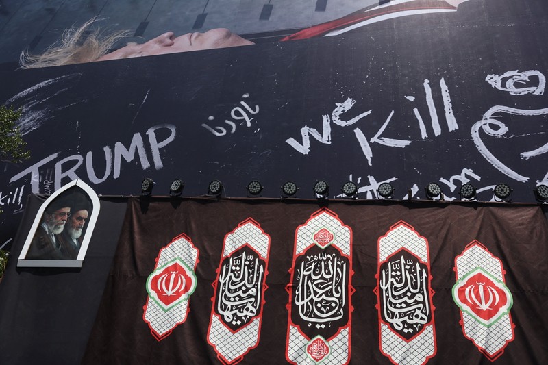 Papan reklame raksasa yang menampilkan ilustrasi Presiden AS Donald Trump berada di dalam peti mati yang terpampang di pusat kota Teheran, Kamis (16/7/2026). (via REUTERS/Majid Asgaripour)