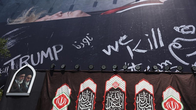 Papan reklame raksasa yang menampilkan ilustrasi Presiden AS Donald Trump berada di dalam peti mati yang terpampang di pusat kota Teheran, Kamis (16/7/2026). (via REUTERS/Majid Asgaripour)