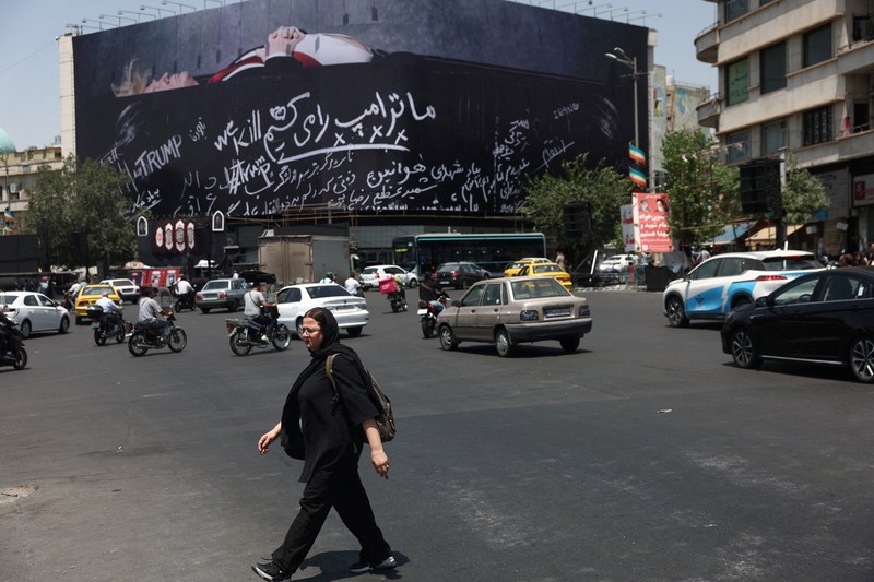 Papan reklame raksasa yang menampilkan ilustrasi Presiden AS Donald Trump berada di dalam peti mati yang terpampang di pusat kota Teheran, Kamis (16/7/2026). (via REUTERS/Majid Asgaripour)