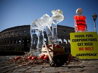 Patung-patung es yang menggambarkan seorang petani dan seorang tukang bangunan, kelompok pekerja yang paling rentan terhadap gelombang panas, yang ditempatkan oleh aktivis Greenpeace, meleleh di bawah sinar matahari, selama demonstrasi untuk menyorot