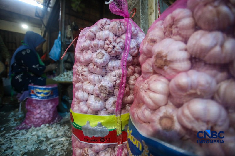 Pekerja mengupas bawang putih di Pasar Induk Kramat Jati, Jakarta, Kamis (16/7/2026). Badan Pusat Statistik (BPS) mencatat Indonesia masih sangat bergantung pada China untuk memenuhi kebutuhan impor bawang putih. (CNBC Indonesia/Faisal Rahman)