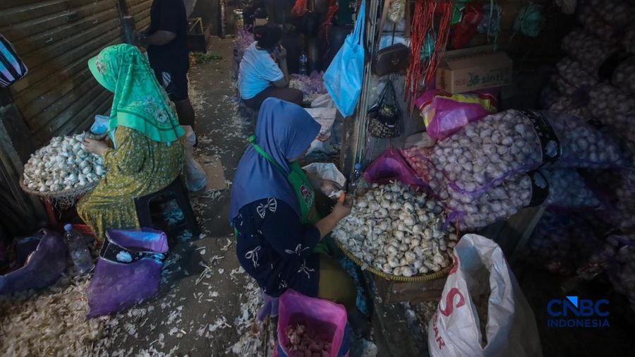 Pekerja mengupas bawang putih di Pasar Induk Kramat Jati, Jakarta, Kamis (16/7/2026). Badan Pusat Statistik (BPS) mencatat Indonesia masih sangat bergantung pada China untuk memenuhi kebutuhan impor bawang putih. (CNBC Indonesia/Faisal Rahman)
