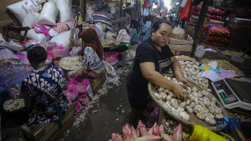 Pekerja mengupas bawang putih di Pasar Induk Kramat Jati, Jakarta, Kamis (16/7/2026). Badan Pusat Statistik (BPS) mencatat Indonesia masih sangat bergantung pada China untuk memenuhi kebutuhan impor bawang putih. (CNBC Indonesia/Faisal Rahman)