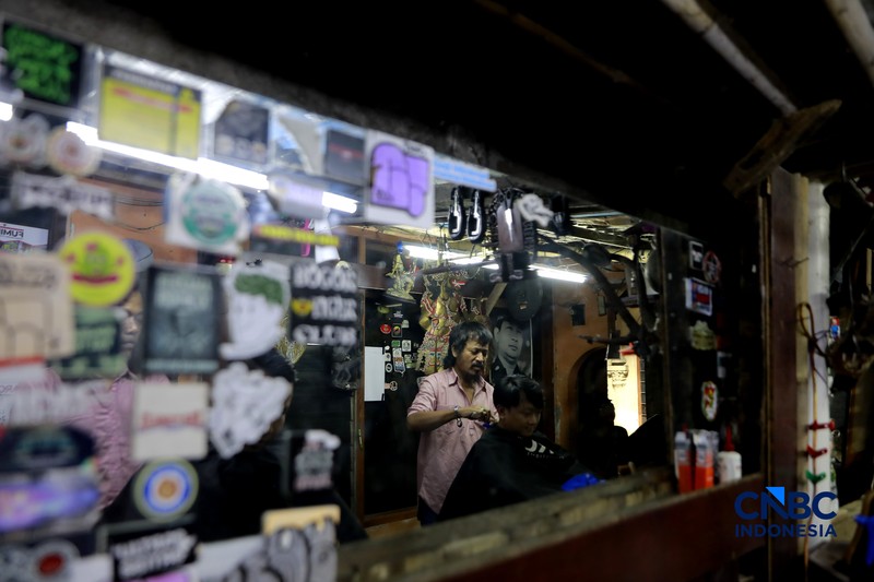 Supri 62 tahun pemilik jasa cukur rambut melayani pelanggan di Kawasan jalan Pemuda, Bogor, Jawa Barat, Kamis, (16/7/2026). (CNBC Indonesia/Muhammad Sabki)