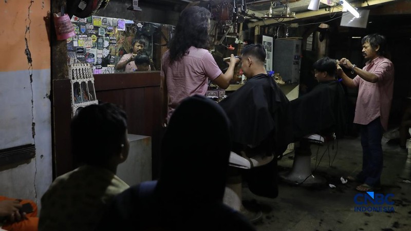 Supri 62 tahun pemilik jasa cukur rambut melayani pelanggan di Kawasan jalan Pemuda, Bogor, Jawa Barat, Kamis, (16/7/2026). (CNBC Indonesia/Muhammad Sabki)
