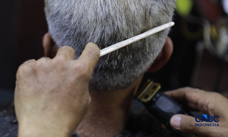 Supri 62 tahun pemilik jasa cukur rambut melayani pelanggan di Kawasan jalan Pemuda, Bogor, Jawa Barat, Kamis, (16/7/2026). (CNBC Indonesia/Muhammad Sabki)