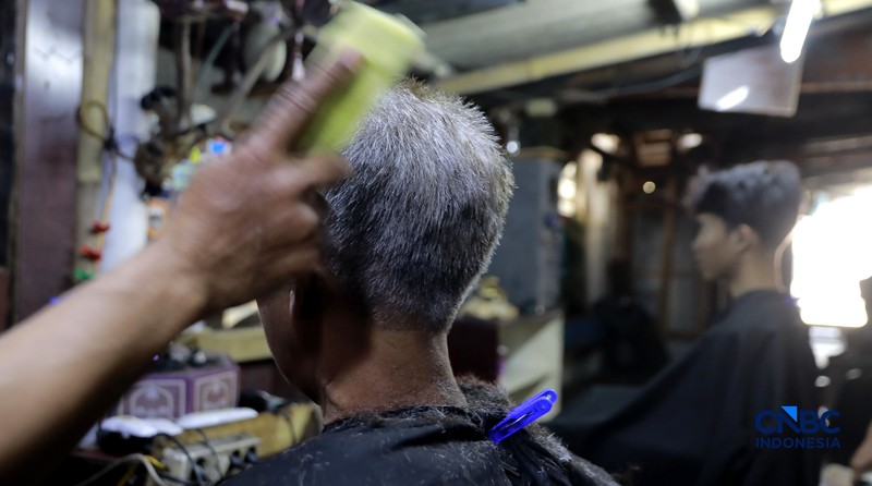 Supri 62 tahun pemilik jasa cukur rambut melayani pelanggan di Kawasan jalan Pemuda, Bogor, Jawa Barat, Kamis, (16/7/2026). (CNBC Indonesia/Muhammad Sabki)