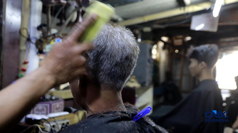 Supri 62 tahun pemilik jasa cukur rambut melayani pelanggan di Kawasan jalan Pemuda, Bogor, Jawa Barat, Kamis, (16/7/2026). (CNBC Indonesia/Muhammad Sabki)