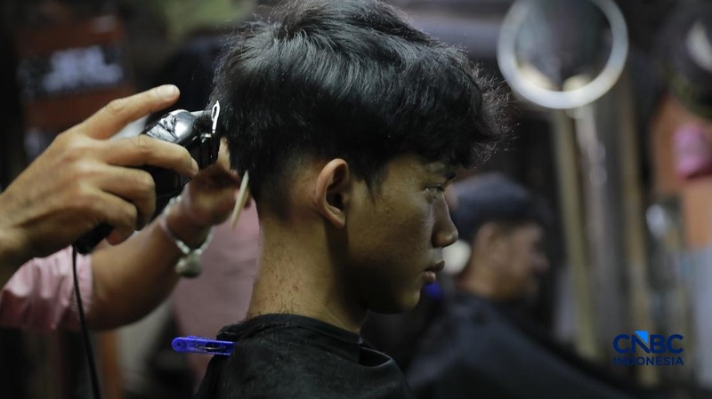Supri 62 tahun pemilik jasa cukur rambut melayani pelanggan di Kawasan jalan Pemuda, Bogor, Jawa Barat, Kamis, (16/7/2026). (CNBC Indonesia/Muhammad Sabki)