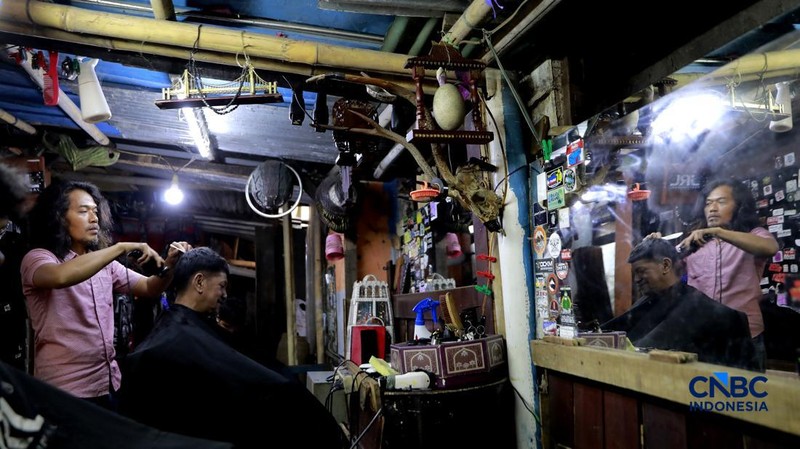 Supri 62 tahun pemilik jasa cukur rambut melayani pelanggan di Kawasan jalan Pemuda, Bogor, Jawa Barat, Kamis, (16/7/2026). (CNBC Indonesia/Muhammad Sabki)
