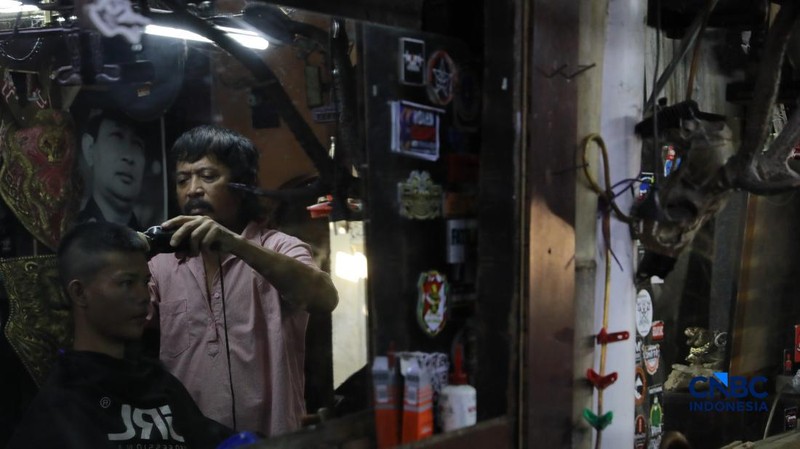 Supri 62 tahun pemilik jasa cukur rambut melayani pelanggan di Kawasan jalan Pemuda, Bogor, Jawa Barat, Kamis, (16/7/2026). (CNBC Indonesia/Muhammad Sabki)