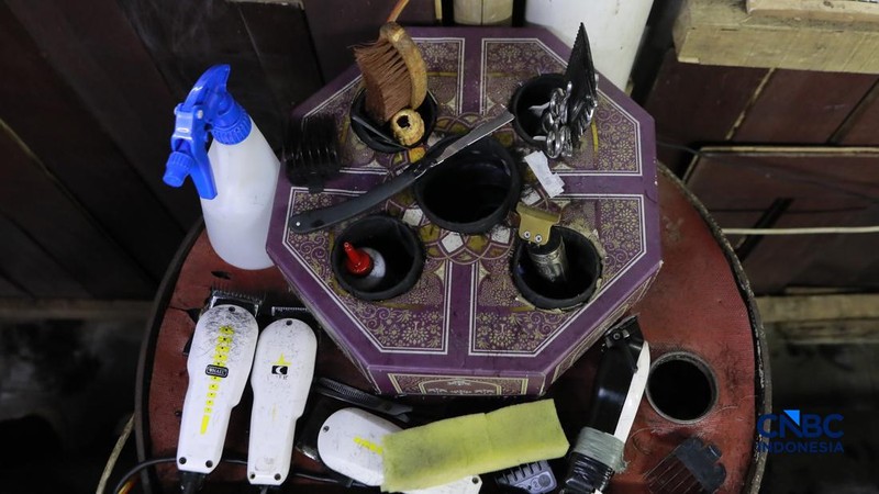 Supri 62 tahun pemilik jasa cukur rambut melayani pelanggan di Kawasan jalan Pemuda, Bogor, Jawa Barat, Kamis, (16/7/2026). (CNBC Indonesia/Muhammad Sabki)