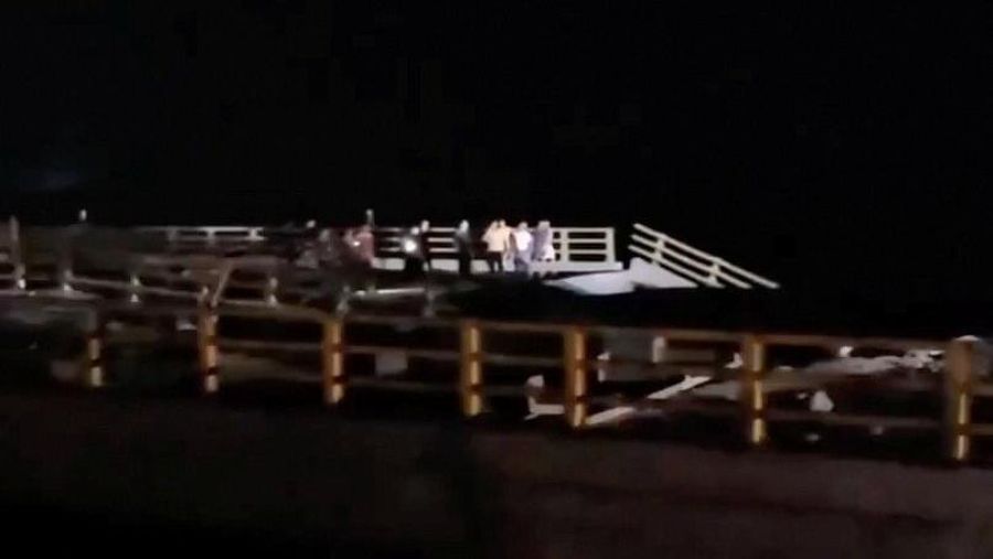 Orang-orang berdiri di dekat bagian jembatan yang rusak akibat serangan, di Bandar Khamir, provinsi Hormozgan, Iran, Kamis (16/7/2026), dalam cuplikan layar yang diperoleh dari video media sosial. (Media Sosial/via REUTERS)