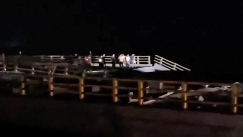 Orang-orang berdiri di dekat bagian jembatan yang rusak akibat serangan, di Bandar Khamir, provinsi Hormozgan, Iran, Kamis (16/7/2026), dalam cuplikan layar yang diperoleh dari video media sosial. (Media Sosial/via REUTERS)