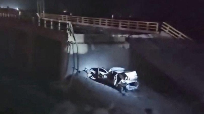Sebuah cahaya menerangi kendaraan yang rusak dan bagian jembatan yang runtuh setelah serangan udara, di Bandar Khamir, provinsi Hormozgan, Iran, 16 Juli 2026, dalam tangkapan layar yang diperoleh dari video media sosial. (Media Sosial/via REUTERS)