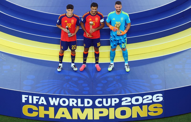 Kapten Spanyol Rodri merayakan penghargaan Bola Emas (Golden Ball) di podium bersama kiper Unai Simon yang meraih Sarung Tangan Emas (Golden Glove) dan bek Pau Cubarsi yang dinobatkan sebagai Pemain Muda Terbaik, usai membawa Spanyol menjuarai Piala Dunia FIFA 2026 di New York/New Jersey Stadium, East Rutherford, New Jersey, Amerika Serikat, Minggu (19/7/2026). (REUTERS/Mike Segar)