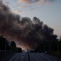 Kepulan asap membubung di atas kota saat sebuah mobil melaju di jalan raya setelah serangan rudal Rusia, di tengah serangan Rusia terhadap Ukraina, di Kyiv, Ukraina, 19 Juli 2026. (REUTERS/Thomas Peter)